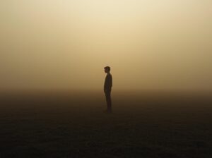 Arme locker an den Seiten, Blick nach vorn – nicht wartend, sondern präsent. Um sie herum breitet sich Stille aus