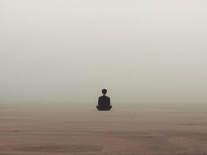 A minimalist, contemplative scene showing a single person