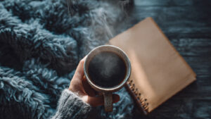 A-hand-holding-a-cup-of-steaming-coffee-or-tea-nea (1)